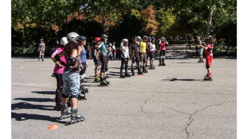 屋外でのスケート教室の様子。先生も複数の生徒さん達も全員がヘルメットとプロテクターを装着している